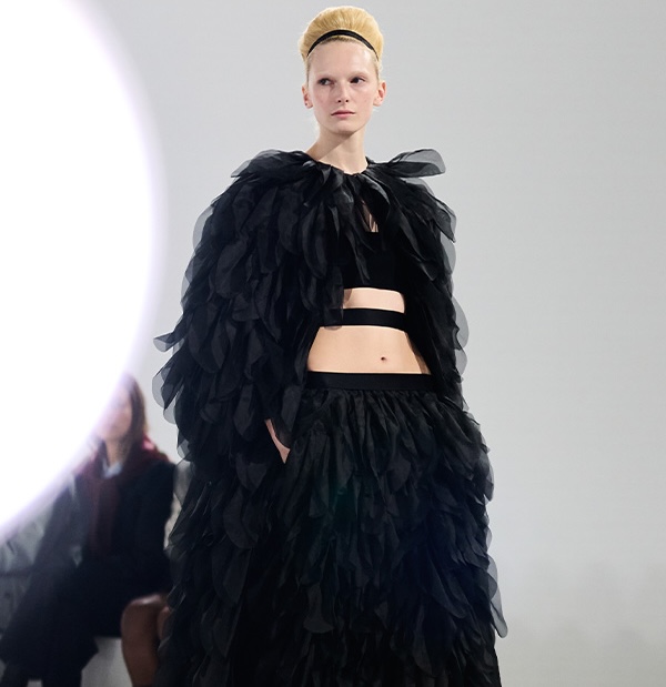 Max-Mara-Show Frühjahr/Sommer 2026 – Bild eines Models auf dem Laufsteg im schwarzem Look mit Jacke und Rock mit Details.